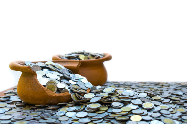 Münzen in zerbrochenem Glas aus auf einem Haufen Lose Münze mit weißem Hintergrund, Geldstapel für Geschäftsplanung Investition und Sparkonzept - Foto, Bild
