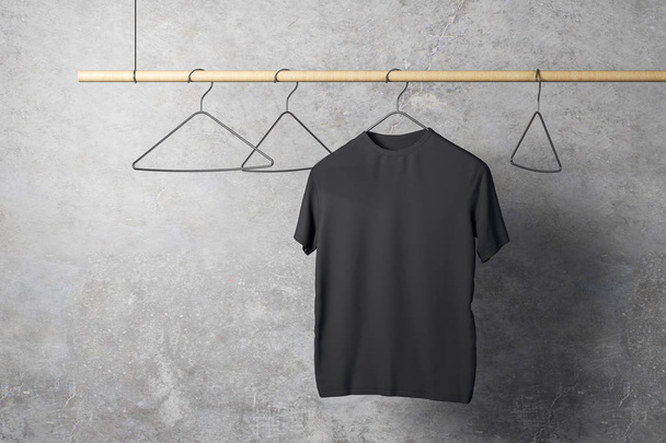 Empty one black tshirt on hanger. Concrete wall background. Design, store and style concept. Mock up, 3D Rendering  - Фото, зображення