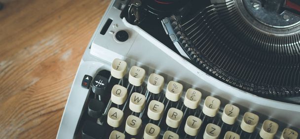 Vintage typewriter on a wooden desk, cutout - Foto, afbeelding