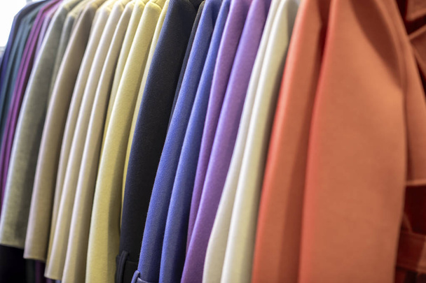 Mehrfarbiger Mantel auf Kleiderbügel in einem Bekleidungsgeschäft - Foto, Bild