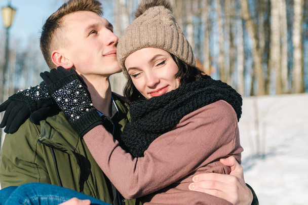 Bella giovane coppia innamorata nel parco in una chiara giornata invernale soleggiata. Il giovane tiene la sua ragazza
 - Foto, immagini