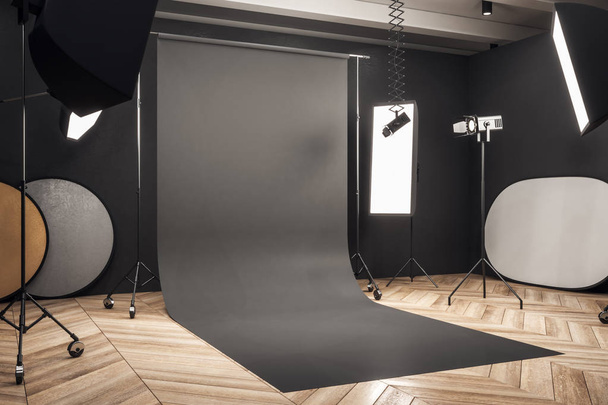 Side view of modern photo studio interior with black background, professional equipment and wooden floor. Mock up, 3D Rendering  - Foto, imagen