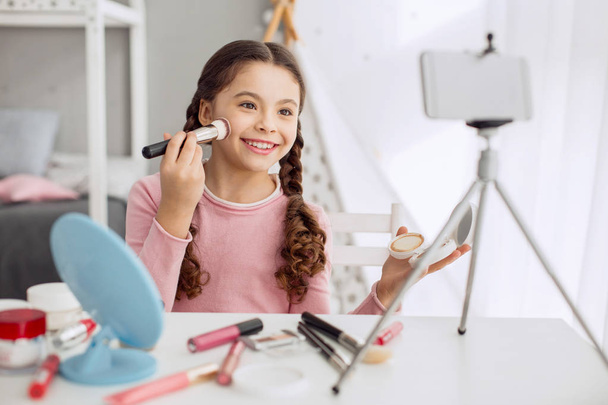 Menina bonito filmar tutorial de maquiagem com seu telefone
 - Foto, Imagem
