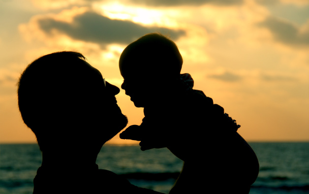 otec a dcera hraje na pláži při západu slunce - Fotografie, Obrázek