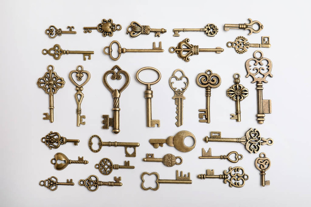 Bronze vintage ornate keys on white background, top view - Foto, imagen