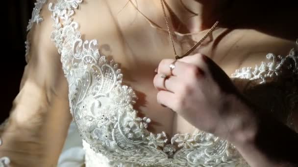Gyönyörű menyasszony test. A menyasszony az ablak áll a fénysugarak a nap esik a testén. A menyasszony tartja kezében a mellét közelében. - Felvétel, videó