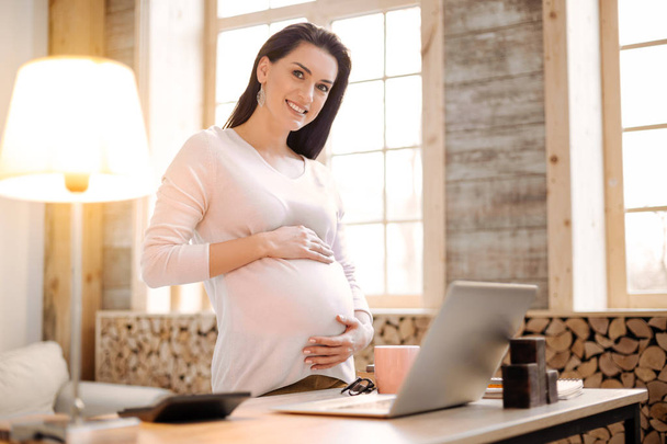 Jolly pregnant woman working while pregnancy - Foto, Bild