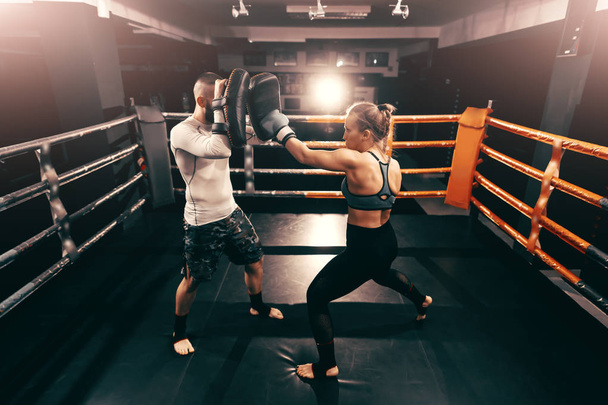 強い筋肉ボクサー白人女性を蹴るとリングの訓練を持っていること. - 写真・画像