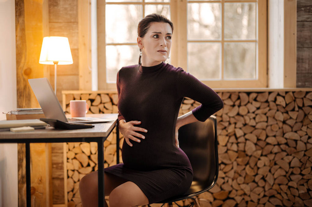 Worried upset pregnant businesswoman feeling contractions - Fotoğraf, Görsel