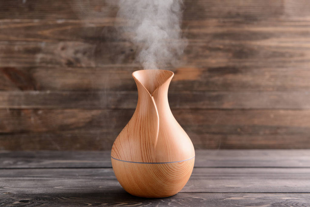 Диффузер ароматического масла на деревянном фоне
 - Фото, изображение