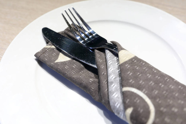 Knife and fork on white plate in restaurant - Photo, Image