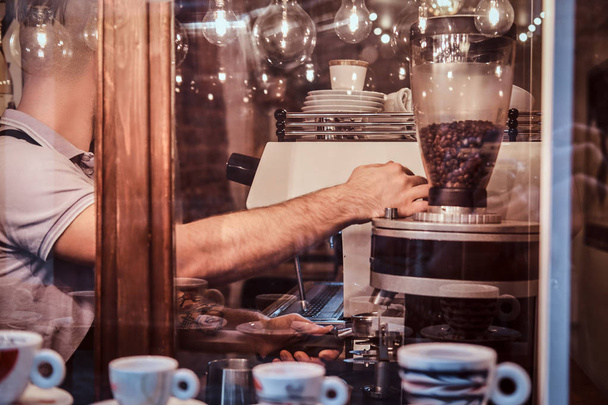 Ο άνθρωπος barista που εργάζονται σε μια μοντέρνα καφετέρια, έξω από την προβολή - Φωτογραφία, εικόνα