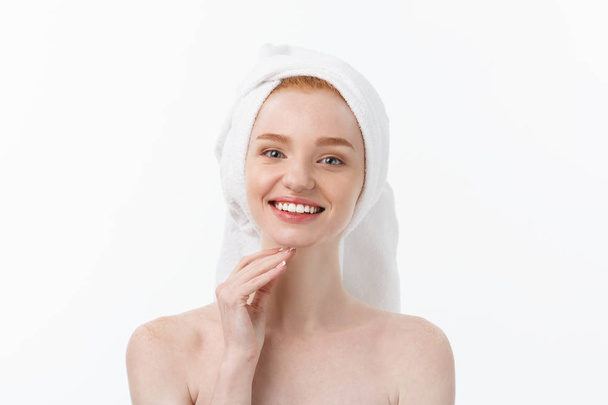 Überrascht schöne junge Frau nach dem Bad mit einem Handtuch auf dem Kopf isoliert auf weißem Hintergrund. Hautpflege und Wellness-Thema. - Foto, Bild