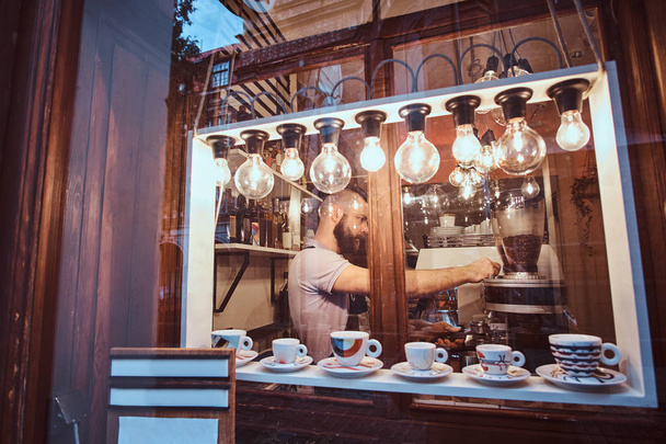 The barista man working in a trendy coffee shop, outside view - Photo, Image