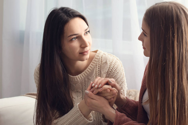 Vriend helpen jonge depressieve vrouw thuis. Stoppen van een zelfmoord - Foto, afbeelding