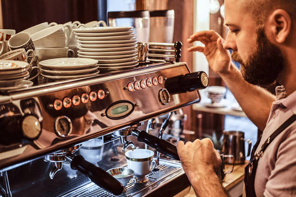 Close-up photo of a stylish barista working on a coffee machine in a coffee shop - Foto, imagen