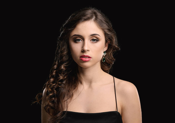 Young woman with beautiful jewelry on dark background - Фото, зображення