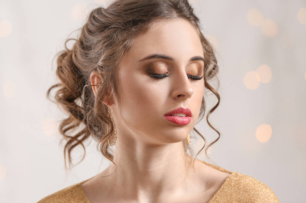 Mujer joven con hermosas joyas contra luces desenfocadas
 - Foto, Imagen