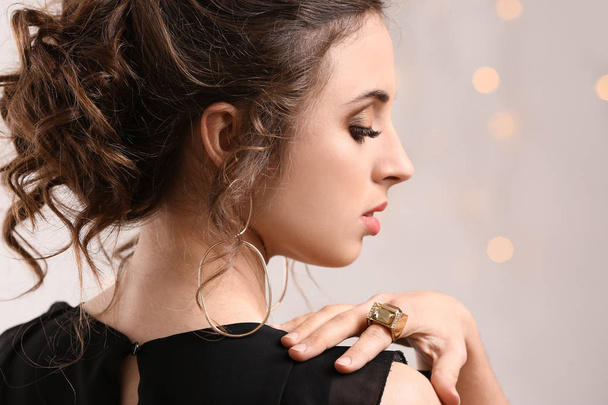 Jeune femme avec de beaux bijoux contre les lumières déconcentrées
 - Photo, image