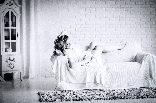 black and white photo in retro style. happy young pregnant woman lying on couch - Foto, immagini