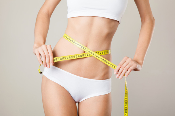 Woman measuring her waistline. Perfect Slim Body. Diet - 写真・画像