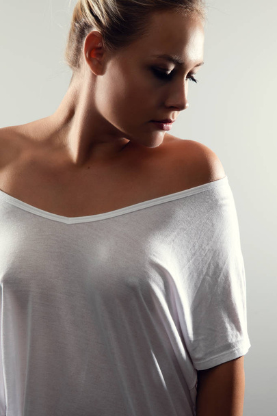 Studio ritratto di bella donna con capelli biondi e t-shirt bianca
 - Foto, immagini