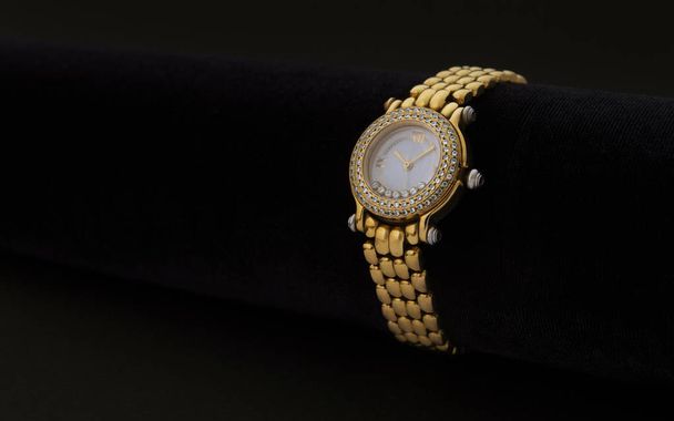 Zegarek na rękę złote kobiety z kamieni szlachetnych na ciemnym tle - Zdjęcie, obraz