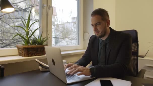 zakenman die op laptop in office ogen gekwetst door zwarte venster tabel werken met laptop papieren telefoon executive corporate - Video