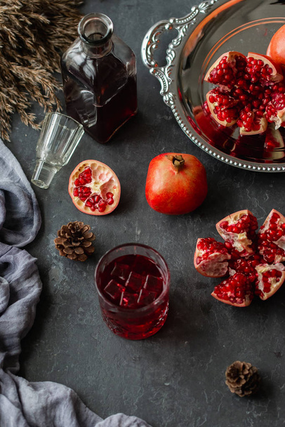 Glass of fresh juice and pomegranates on table - Photo, Image