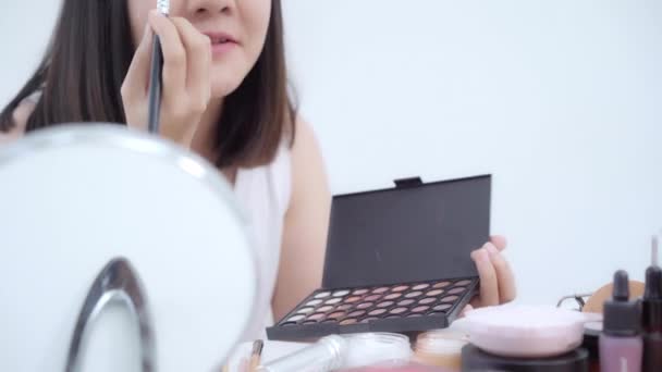 美容ブロガーは、ビデオ録画のためのカメラの前に座って美容化粧品を紹介します。幸せな美しい若いアジア女性使用化粧品レビューは、チュートリアルを構成するソーシャル ネットワークに放送します。. - 映像、動画