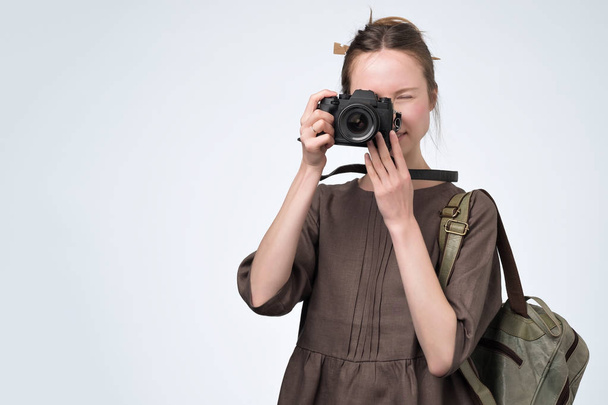 joven europeo chica retro posando con una cámara en el estudio, tomando fotos. Mujer haciendo fotos durante las vacaciones
 - Foto, imagen
