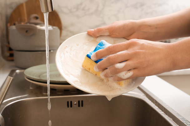 台所の洗面台で食器を洗う女性 - 写真・画像