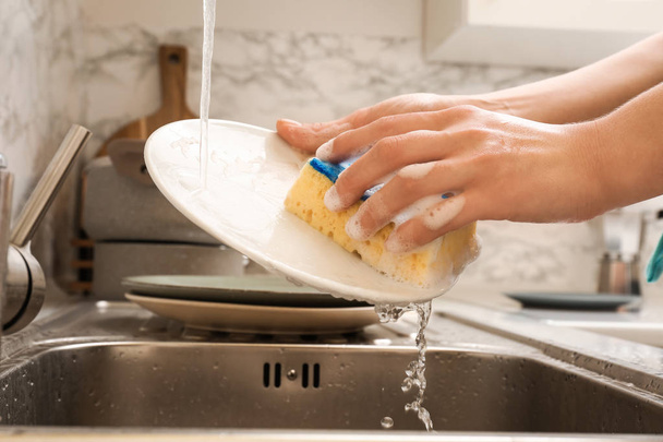 femme lave la vaisselle dans l'évier - Photo, image