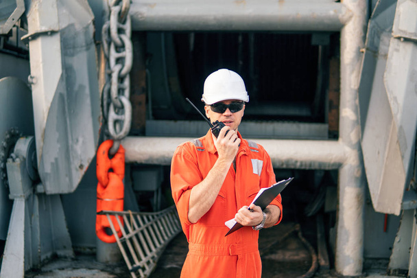 Oficial de convés no convés da embarcação offshore detém rádio walkie-talkie VHF
 - Foto, Imagem