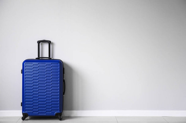 Packed suitcase near light wall - Foto, Imagen