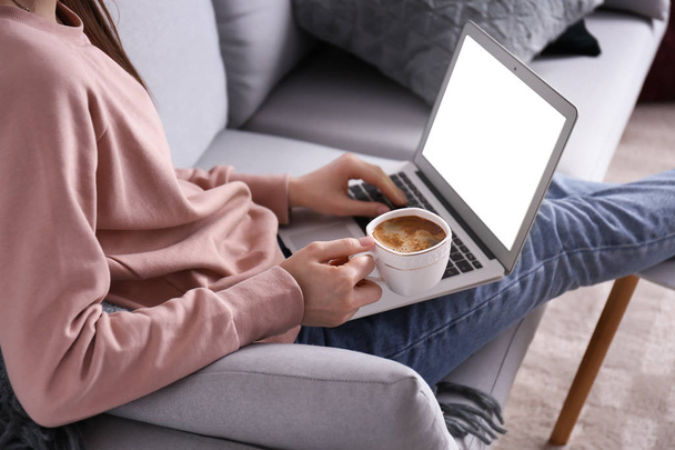 Jovem mulher trabalhando em laptop e beber café em casa
 - Foto, Imagem