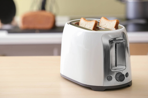 Toaster mit Brotscheiben auf dem Tisch - Foto, Bild