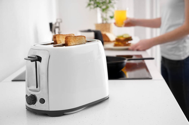 Toaster with bread slices on kitchen table - 写真・画像