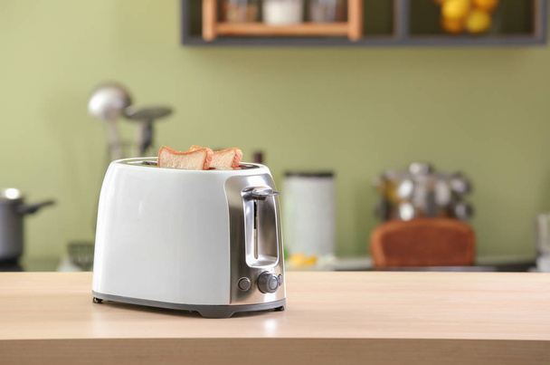 Toaster mit Brotscheiben auf dem Tisch - Foto, Bild