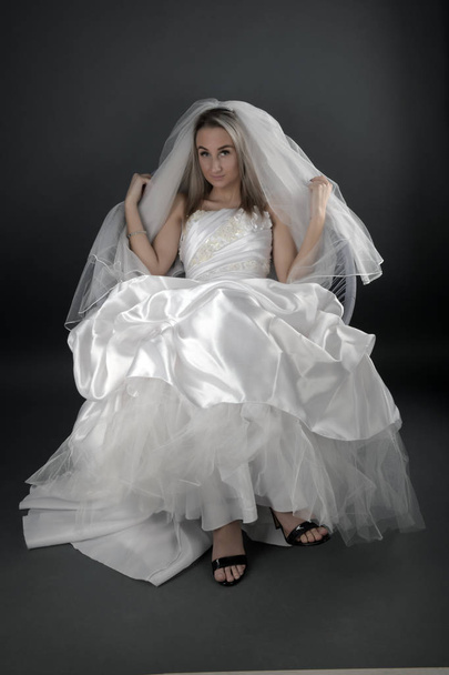 Linda noiva loira em um vestido branco em um fundo preto - Foto, Imagem