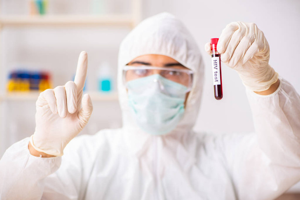Молодой симпатичный лаборант тестирует образцы крови в больнице  - Фото, изображение