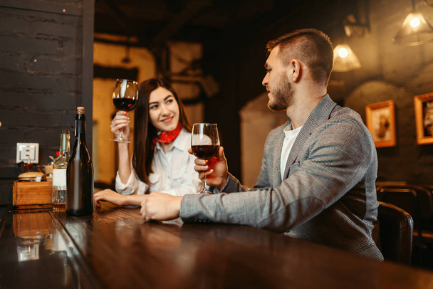Mężczyzna i kobieta flirtuje w bar, para o drewniany kontuar. Miłośników Senslis w pubie, mąż i żona razem relaks w nocnym klubie - Zdjęcie, obraz