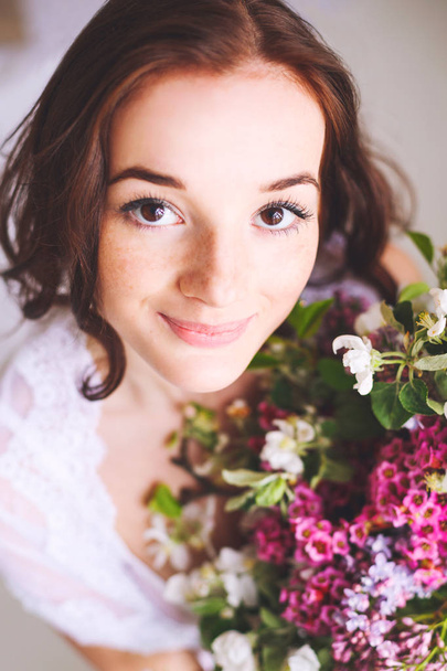 Young bride with bouquet of flowers smiling - 写真・画像
