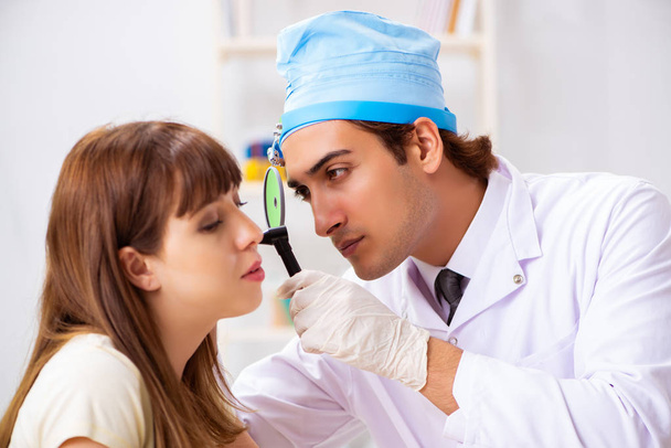 Jovem mulher visting masculino médico otorrinolaringologista
 - Foto, Imagem