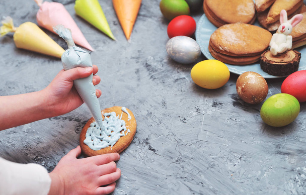 Mains d'enfant peignant des biscuits de Pâques
.  - Photo, image