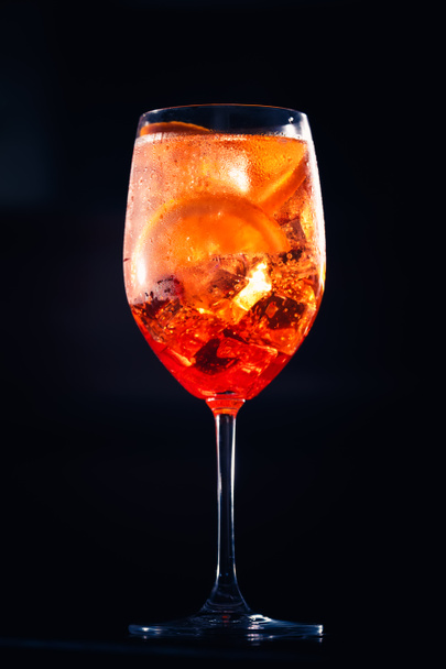 Stylish alcoholic aperol spritz trendy cocktail with orange slice on black background. Champagne cocktail. - Φωτογραφία, εικόνα
