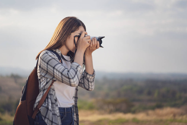 tourist woman taking a photo with her camera in nature - Valokuva, kuva