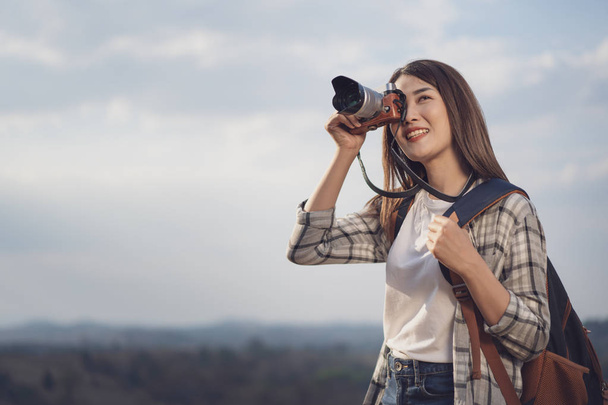 toeristische vrouw nemen van een foto met haar camera in de natuur - Foto, afbeelding