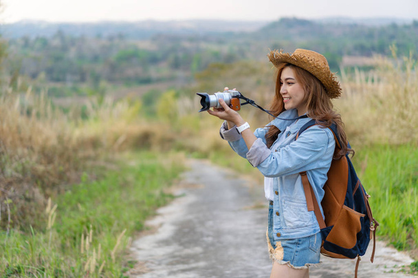 tourist woman taking a photo with her camera in nature - Foto, Imagen