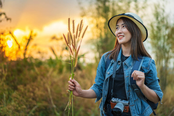 female tourist with backpack and camera in the countryside with sunset - Photo, image